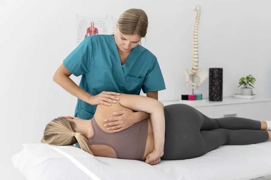 Fisioterapeuta ayudando a una paciente en consulta